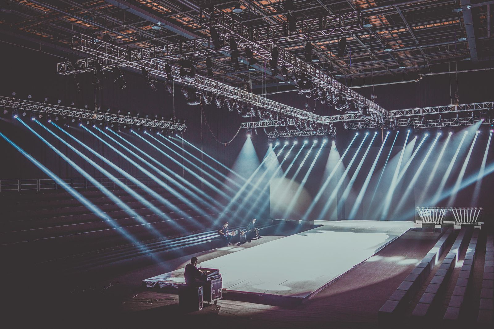 A large-scale international stage being prepared under production lighting